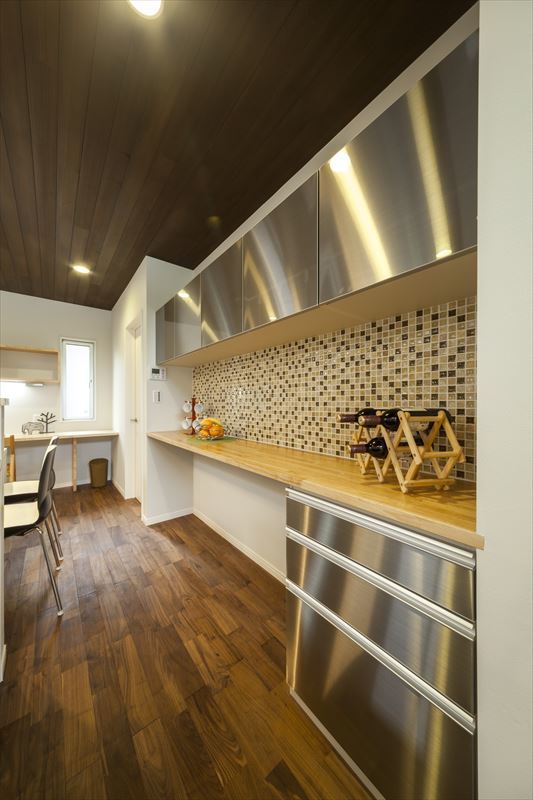 無垢材の床とステンレスのコントラストが美しいキッチン