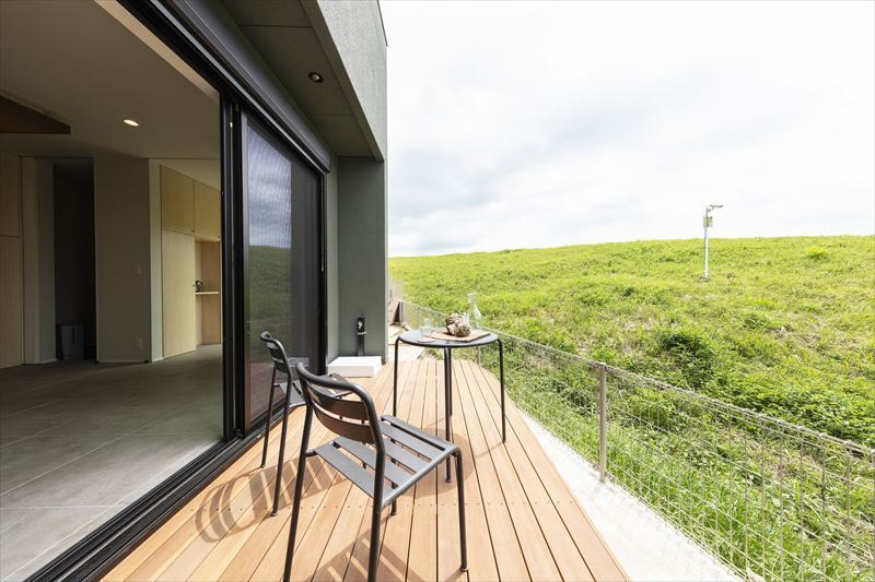 借景を望めるウッドデッキとつながる気持ちの良いリビング