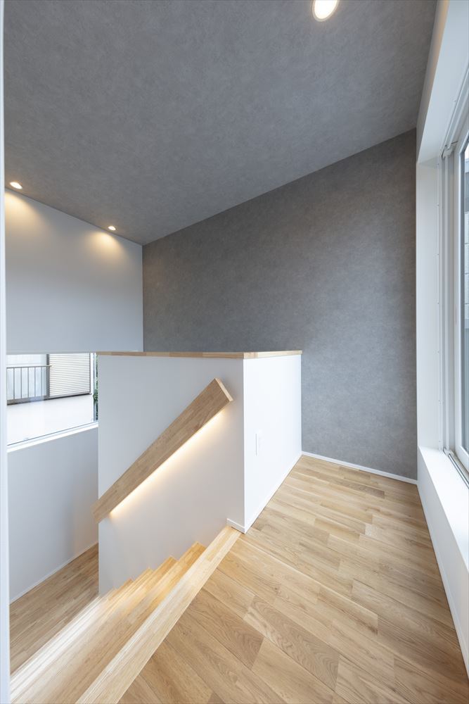 グレーの壁紙がアクセントの階段ホール