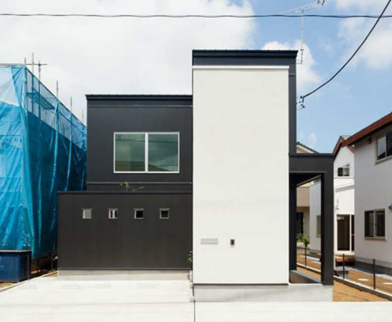 箱のような窓のない白い外観が印象的なモダンな住まい