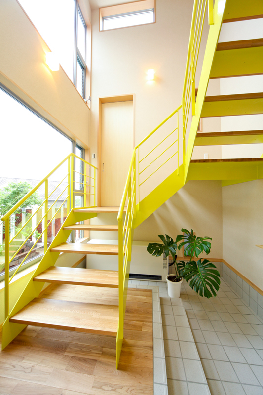 黄色の鉄骨ささら階段が印象的な玄関ホール